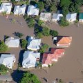 aerial view of the rooves of houses in brown floodwater